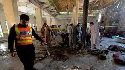 Rescue workers collect remains at the site of a blast in a religious school in Peshawar. AFP