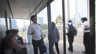 Hot and bothered passengers wait for a bus inside a shelter located on Muroor Road near the Madinat Zayed shopping mall and the Gold Centre in Abu Dhabi, just of the many shelters with a malfunctioning AC or defective automatic doors. Ravindranath K / The National