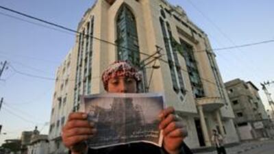 A Palestinian reads leaflets dropped by an Israeli aircraft over their houses in Rafah refugee camp southern Gaza Strip, on Wednesday.