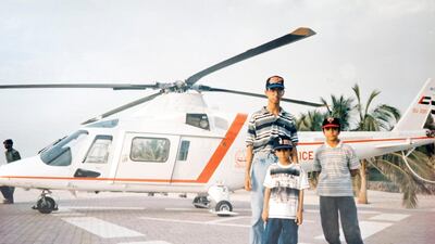 Brothers Ismail Noor, 14 (right), Ayaz Noor, 10 (middle) and Imtiaz Noor ,19, by a helicopter in Jumeirah