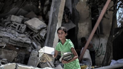 A girl discovers books in rubble in Gaza in July 2014. The lives of Palestinian writers are marked by conflict NurPhoto / Corbis via Getty Images