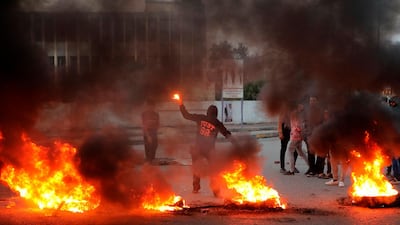 Protesters burn tyres outside the provincial council building during a demonstration demanding better public services and jobs in Basra, Iraq. AP