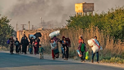 Civilians flee with their belongings amid Turkish bombardment on Syria's northeastern town of Ras Al Ain in the Hasakeh province along the Turkish border. AFP