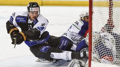 Lugano’s Alessio Bertaggia, left, fights for the puck with Mannheim’s Christopher Fischer and goalkeeper Florian Proske, during the game between Switzerland’s HC Lugano and Germany’s Adler Mannheim, at the 89th Spengler Cup ice hockey tournament in Davos, Switzerland. Gian Ehrenzeller / EPA
