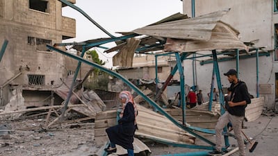 Palestinians survey the damage caused by an Israeli air strike near a UNRWA-run school housing displaced people in the Nuseirat refugee camp in Gaza. EPA
