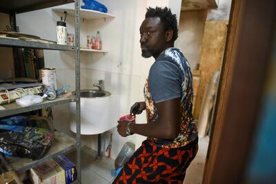 Omar Ba mixes paint in a storage area of his studio in Bambilor, Senegal. Reuters