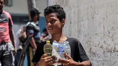 Palestinians receiving food rations from the UNRWA warehouse in Khan Younis in the Gaza Strip on Wednesday. AFP