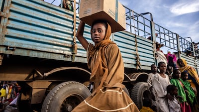 A Sudanese girl who have fled from the war in Sudan with her family carry a box with some of her belongings after arriving at a Transit Centre for refugees in Renk, on February 13, 2024. More than 550,000 people have now fled from the war in Sudan to South Sudan since the conflict exploded in April 2023, according to the United Nations. South Sudan, that has itself recently come out of decades of war, was facing a dire humanitarian situation before the war in Sudan erupted and it is feared to not have the resources to host displaced people. The war-torn country of Sudan is currently ravaged by internal fighting between the Sudanese Army and the paramilitary Rapid Support Forces (RSF). (Photo by LUIS TATO / AFP)
