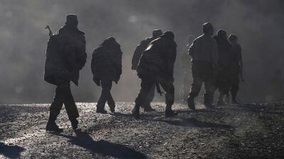 Ethnic Armenian soldiers walk along a road near the border between Nagorno-Karabakh and Armenia.