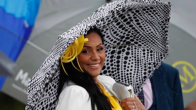 A racegoer poses during the races. Reuters