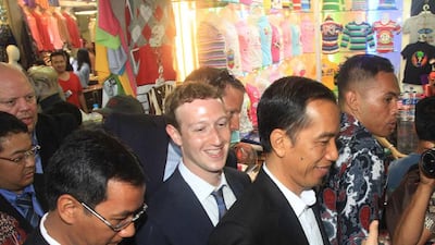Facebook founder Mark Zuckerberg, centre, and Indonesian president-elect Joko Widodo, centre right, visit a traditional market in Jakarta on October 13, 2014. Mr Zuckerberg is on a visit to Indonesia which has the fourth-largest number of Facebook users in the world. Rama/ AFP Photo