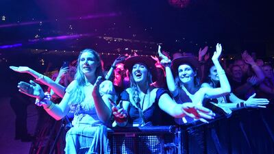 Fans watch Queen and Adam Lambert perform at a concert in Sydney. Australia has a happiness premium of $135,321 per year. Photo: AFP