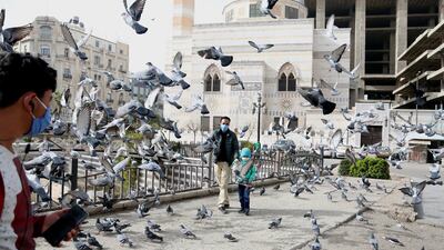 People wearing face masks walk in Damascus, Syria. EPA