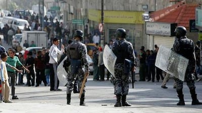 Riot policemen block a road in Amman as protesters demonstrate against the death of a man allegedly caused by police.