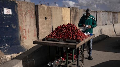 A vendor sells strawberries at the Israeli-controlled Qalandiya checkpoint in the occupied West Bank. AFP