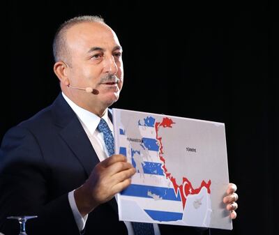 Turkey's Foreign Minister Mevlut Cavusoglu, shows a map of Greece and Turkey as he speaks during a conference in Bratislava, Slovakia. AP