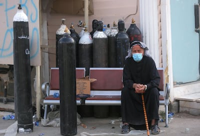 An Iraqi man waits next to oxygen cylinders for his wife, a patient with Covid-19, at the Ibn Al Khateeb Hospital, Baghdad, April 25. AFP
