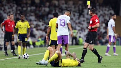 Al Ain's Houssine Rahimi is shown a yellow card for a challenge on Inigo Martinez of Al Nassr. Chris Whiteoak / The National