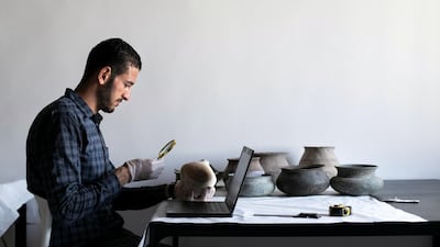 Ismail Draz, head of the collection unit at Ras Al Khaimah's National Museum, examines an artefact. All photos by Reem Mohammed / The National