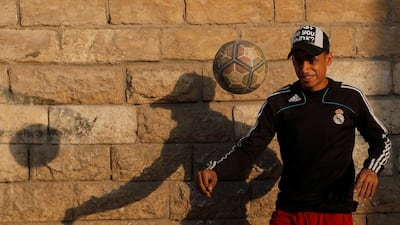 A boy plays football in front of closed Al-Hakim bi-Amr Allah mosque at El Moez Street in old Islamic Cairo. Reuters