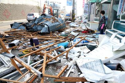 A woman looks at debris caused by Typhoon Maysak in Pohang, South Korea. Yonhap via Reuters