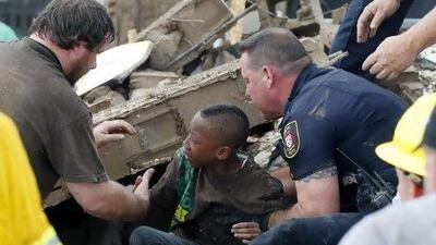 A boy is pulled from beneath a collapsed wall at the Plaza Towers Elementary School, Moore, Oklahoma.
