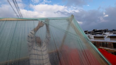 A displaced man adjusts his tent following heavy rains. Reuters