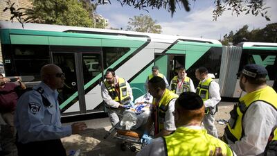 Paramedics carry the body of an Israeli who died in a shooting attack on a Jerusalem bus. Sebastian Scheiner / AP Photo