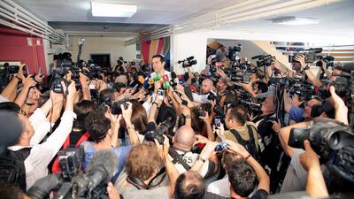 Greece’s prime minister Alexis Tsipras, centre, speaks to the media after voting at a polling station in Athens. Spyros Tsakiris / AP Photo