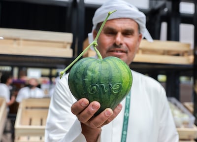A farmer proudly displays a heart-shaped watermelon at the major agriculture event in Al Ain. Victor Besa / The National