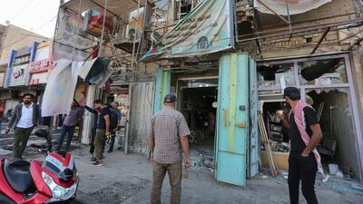 Iraqis stand at the site of a bomb explosion near Baghdad's Tahrir Square on November 16, 2019. AFP