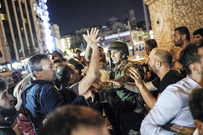 People react towards a Turkish soldier at Taksim Square in Istanbul on July 16, 2016, following a coup attempt. Halit Onur Sandal / AFP Photo