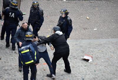 Elysee Chief Security Officer Alexandre Benalla (C) wearing a police visor as he drags away a demonstrator during May 1 protests in Paris. AFP