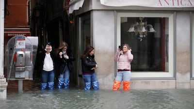 Tourists take pictures of a flooded Venice, Italy. AP Photo