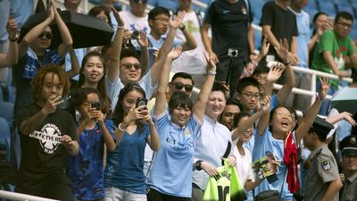 Chinese fans of Manchester City cheer during the team’s training session at the Olympic Sports Center Stadium in Beijing, Sunday, July 24, 2016. Mark Schiefelbein / AP Photo