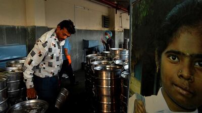 A worker loads containers of food onto a truck at the non-profit Akshaya Patra Foundation.