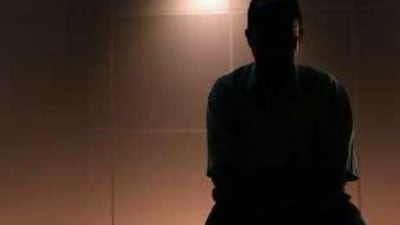 An Indian expatriate with a financial crisis sits alone worrying about his problems.