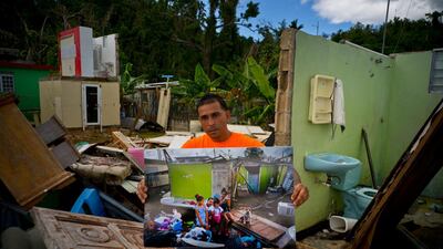 Arden Dragoni holds a printed photo taken on October 5, 2017. The unemployed construction worker and security guard is currently separated from his family while his wife and his children live in a subsidised apartment, and he lives with his father. "The hurricane brought us many calamities but my lesson was to value my family from my heart," said Dragoni.