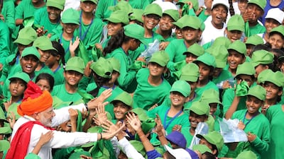 Mr. Modi greets school children after he addressed the nation. EPA