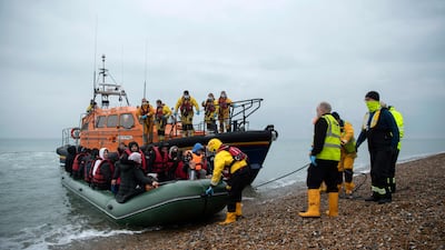 Migrants are helped ashore from a lifeboat at a beach in Dungeness, on the south-east coast of England, on Wednesday after being rescued while crossing the English Channel. AFP