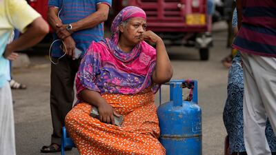 A woman sits outside a police station during a protest in Colombo to demand cooking gas. AP