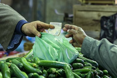 Buying vegetables at a Cairo market. Egypt still imports some of its food needs, putting pressure on its currency. Bloomberg