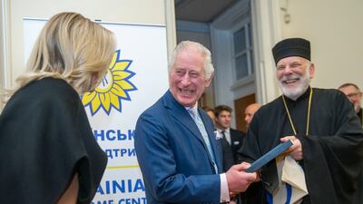 Britain's King Charles III laughs during a visit to a new welcome centre for Ukrainians in London. AP
