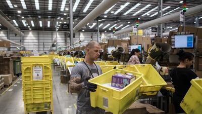 Employees pack boxes of merchandise at an Amazon.com fulfillment center in Peterborough, UK. Amazon has forecast a potential quarterly loss for the first time in two years. Simon Dawson/Bloomberg