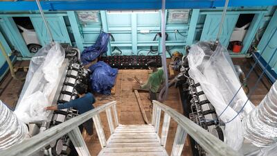 Engineers in the engine room with the two 16 cylinder Mitsubishi diesel engines. Antonie Robertson / The National