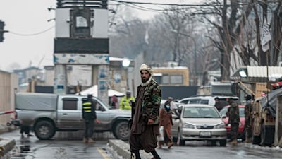 Taliban fighters stand guard at the scene of the bomb blast. AFP