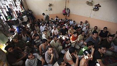 Men sit in a crowded cell in a jail in Baghdad, where human rights groups say inmates are kept in appalling conditions and routinely tortured.