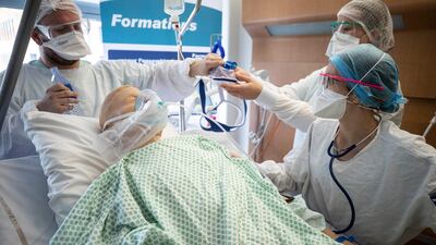 A doctor teaches on a mannequin how to treat a coronavirus patient during a training session for nurses at the Nouvel Hopital Civil of Strasbourg, eastern Franc. AP