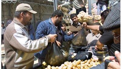 Palestinians buy potatoes in Ramallah's open-air market. A lot of Israeli goods retail for half as much as West Bank products because production is cheaper. AFP