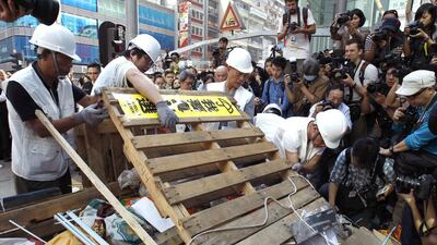 Workers representing bailiffs demolish a barricade on one of the main streets under a court injunction at Mong Kok shopping district in Hong Kong. Hong Kong authorities encountered little resistance as they began clearing part of a pro-democracy protest camp in the bustling district of Mong Kok on Tuesday following a court order to reopen a road. Liau Chung-ren / Reuters